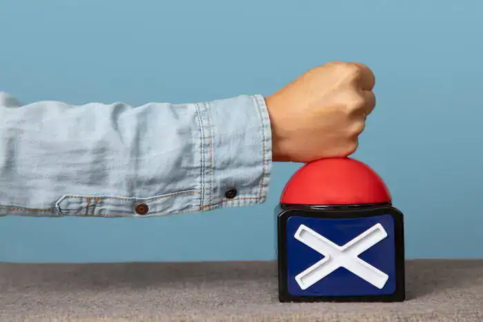 A hand pressing down on a red cancel button.